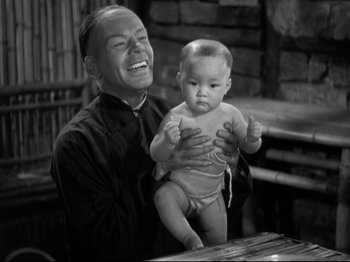 Movie still from “The Good Earth” (1937), directed by Sidney Franklin – A man holding a baby and laughing; Medium shot, High angle