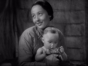Movie still from “The Good Earth” (1937), directed by Sidney Franklin – An old photo of a woman holding a baby; Close Up shot, High angle