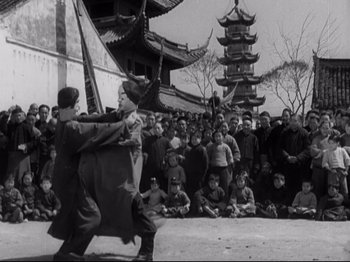 Movie still from “The Good Earth” (1937), directed by Sidney Franklin – A group of people in a courtyard with a crowd watching; Wide shot, Low angle