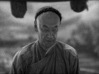 Movie still from “The Good Earth” (1937), directed by Sidney Franklin – An older man wearing a monk's outfit; Close Up shot, High angle