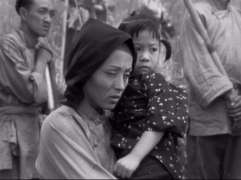 Movie still from “The Good Earth” (1937), directed by Sidney Franklin – An older woman holding a young child in a black and white photo; Medium shot, High angle