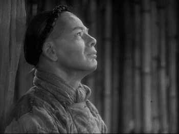 Movie still from “The Good Earth” (1937), directed by Sidney Franklin – A man with a beard is looking up at the sky; Close Up shot, Low angle