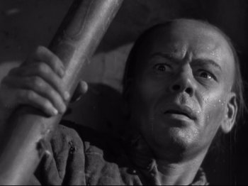 Movie still from “The Good Earth” (1937), directed by Sidney Franklin – A man holding a baseball bat while looking into the distance; Close Up shot, Low angle