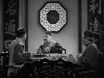 Movie still from “The Good Earth” (1937), directed by Sidney Franklin – A group of men sitting around a table; Wide shot, High angle