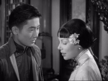 Movie still from “The Good Earth” (1937), directed by Sidney Franklin – A man and a woman standing next to each other in a room; Close Up shot, Over the shoulder angle