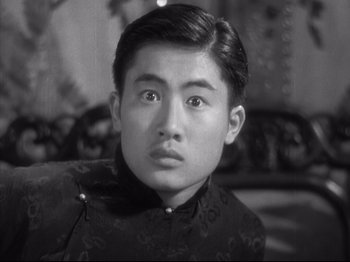 Movie still from “The Good Earth” (1937), directed by Sidney Franklin – A young man in a black and white photo looking at the camera; Close Up shot, Low angle