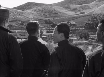 Movie still from “The Good Earth” (1937), directed by Sidney Franklin – A black and white photo of a group of people looking out over a valley; Medium shot, Low angle
