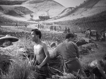 Movie still from “The Good Earth” (1937), directed by Sidney Franklin – A group of people in a field with a mountain in the background; Wide shot, High angle