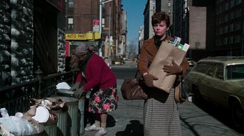 Movie still from “The Goodbye Girl” (1977), directed by Herbert Ross – A woman is holding a bag of papers; Wide shot, Low angle