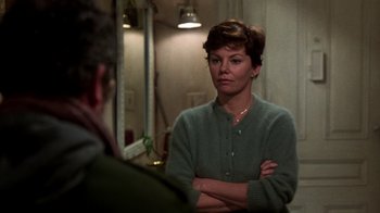 Movie still from “The Goodbye Girl” (1977), directed by Herbert Ross – A woman standing in front of a mirror with her arms crossed; Medium shot, Over the shoulder angle