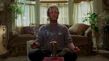Movie still from “The Goodbye Girl” (1977), directed by Herbert Ross – A man sitting on the ground with a candle in his hand; Medium shot, Low angle