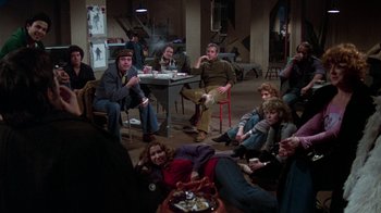 Movie still from “The Goodbye Girl” (1977), directed by Herbert Ross – A group of people sitting and standing around a table; Wide shot, High angle
