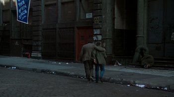 Movie still from “The Goodbye Girl” (1977), directed by Herbert Ross – Two people walking down a street near a building; Wide shot, Over the shoulder angle