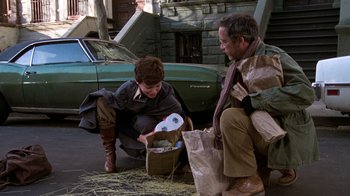 Movie still from “The Goodbye Girl” (1977), directed by Herbert Ross – A man and a woman sitting on the side of the street; Wide shot, Low angle