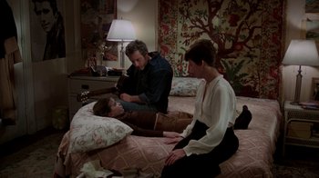 Movie still from “The Goodbye Girl” (1977), directed by Herbert Ross – A group of people sitting on top of a bed in a room; Wide shot, High angle