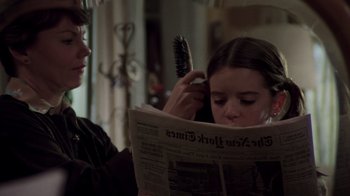 Movie still from “The Goodbye Girl” (1977), directed by Herbert Ross – A young girl brushing her hair while reading a newspaper; Close Up shot, Over the shoulder angle