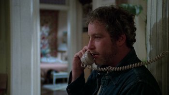 Movie still from “The Goodbye Girl” (1977), directed by Herbert Ross – A man talking on a phone while sitting in a room; Close Up shot, Low angle