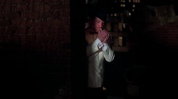 Movie still from “The Goodbye Girl” (1977), directed by Herbert Ross – A man standing in the dark holding his hands in front of his face; Medium shot, High angle