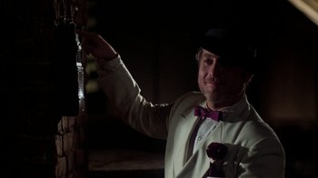 Movie still from “The Goodbye Girl” (1977), directed by Herbert Ross – A man wearing a suit and bow tie holding a glass; Medium shot, Over the shoulder angle