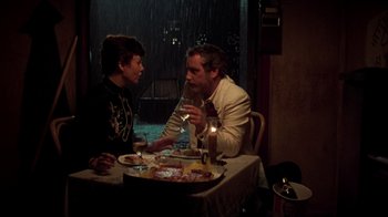 Movie still from “The Goodbye Girl” (1977), directed by Herbert Ross – A man and a woman sitting at a table with a glass of wine; Medium shot, High angle
