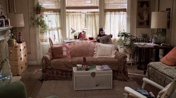 Movie still from “The Goodbye Girl” (1977), directed by Herbert Ross – A woman sitting on top of a couch in a living room; Wide shot, High angle