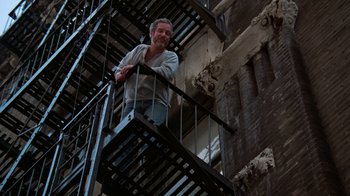 Movie still from “The Goodbye Girl” (1977), directed by Herbert Ross – A man standing on a fire escape of a building; Wide shot, Low angle