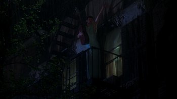 Movie still from “The Goodbye Girl” (1977), directed by Herbert Ross – A woman standing on a fire escape at night; Wide shot, Low angle