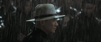 Movie still from “The Grandmaster” (2013), directed by Kar-Wai Wong – A man wearing a white hat in the rain; Close Up shot, Low angle
