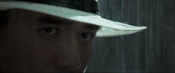 Movie still from “The Grandmaster” (2013), directed by Kar-Wai Wong – A person wearing a hat looking out of a window; Extreme Close Up shot, Over the shoulder angle