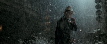 Movie still from “The Grandmaster” (2013), directed by Kar-Wai Wong – A man wearing a hat is standing in the pouring rain; Medium shot, Low angle
