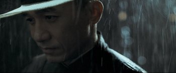 Movie still from “The Grandmaster” (2013), directed by Kar-Wai Wong – A person wearing a hat in the rain; Close Up shot, Over the shoulder angle