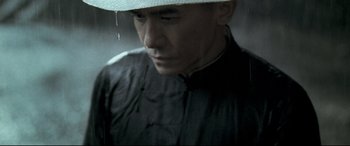 Movie still from “The Grandmaster” (2013), directed by Kar-Wai Wong – A man wearing a white hat standing in the rain; Close Up shot, Low angle