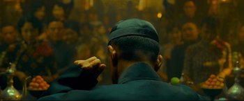 Movie still from “The Grandmaster” (2013), directed by Kar-Wai Wong – A man in a black hat is looking at a crowd; Close Up shot, Over the shoulder angle