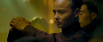 Movie still from “The Grandmaster” (2013), directed by Kar-Wai Wong – A person holding something in his hand; Close Up shot, Low angle