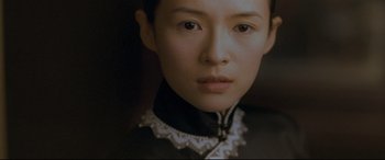 Movie still from “The Grandmaster” (2013), directed by Kar-Wai Wong – A person wearing a black and white shirt; Close Up shot, Over the shoulder angle