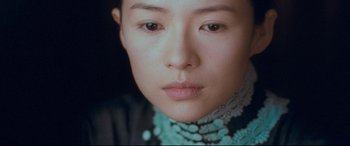 Movie still from “The Grandmaster” (2013), directed by Kar-Wai Wong – A person wearing a necklace; Close Up shot, High angle