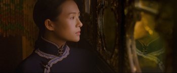 Movie still from “The Grandmaster” (2013), directed by Kar-Wai Wong – A woman looking out of a window in a dark room; Close Up shot, Over the shoulder angle