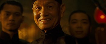 Movie still from “The Grandmaster” (2013), directed by Kar-Wai Wong – An older man wearing a black shirt and a black hat; Close Up shot, Low angle