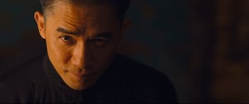 Movie still from “The Grandmaster” (2013), directed by Kar-Wai Wong – A person looking at the camera; Close Up shot, Low angle