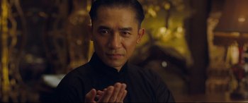 Movie still from “The Grandmaster” (2013), directed by Kar-Wai Wong – A man in a black shirt claps his hands; Close Up shot, Low angle