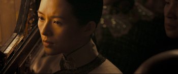 Movie still from “The Grandmaster” (2013), directed by Kar-Wai Wong – A young man in a white shirt is looking to his left; Close Up shot, Over the shoulder angle