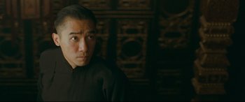 Movie still from “The Grandmaster” (2013), directed by Kar-Wai Wong – A man in a black shirt is looking at the camera; Close Up shot, Over the shoulder angle