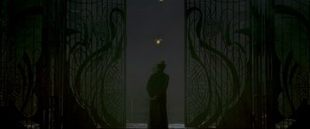Movie still from “The Grandmaster” (2013), directed by Kar-Wai Wong – A man standing in front of an entrance to a building at night; Wide shot, Low angle