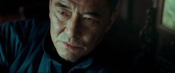 Movie still from “The Grandmaster” (2013), directed by Kar-Wai Wong – A man's face in a dark room; Close Up shot, Low angle