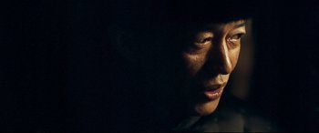 Movie still from “The Grandmaster” (2013), directed by Kar-Wai Wong – A man's face in the dark; Close Up shot, Low angle