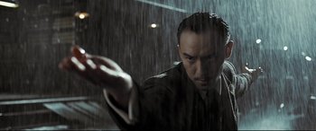 Movie still from “The Grandmaster” (2013), directed by Kar-Wai Wong – A man standing in the middle of a rain storm holding his hand out; Close Up shot, Low angle