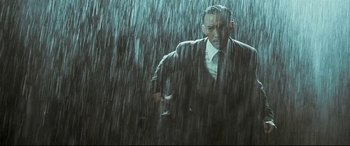 Movie still from “The Grandmaster” (2013), directed by Kar-Wai Wong – A man in a suit and tie standing in the rain; Medium shot, Low angle