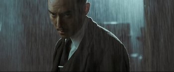 Movie still from “The Grandmaster” (2013), directed by Kar-Wai Wong – A man wearing a suit and tie standing in the rain; Close Up shot, Low angle