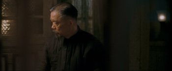 Movie still from “The Grandmaster” (2013), directed by Kar-Wai Wong – An older man in a black shirt is looking at the camera; Close Up shot, Over the shoulder angle
