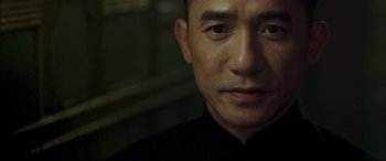 Movie still from “The Grandmaster” (2013), directed by Kar-Wai Wong – A person wearing a black shirt; Close Up shot, Over the shoulder angle
